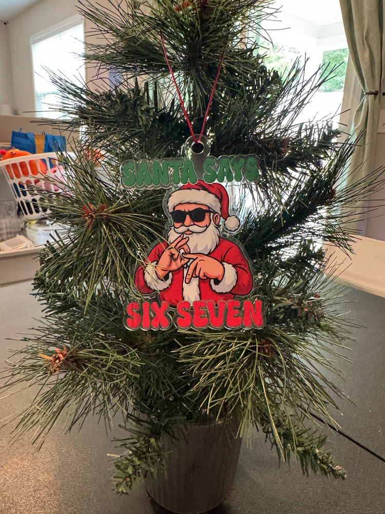 Santa Says Six Seven acrylic ornament hanging on a Christmas tree